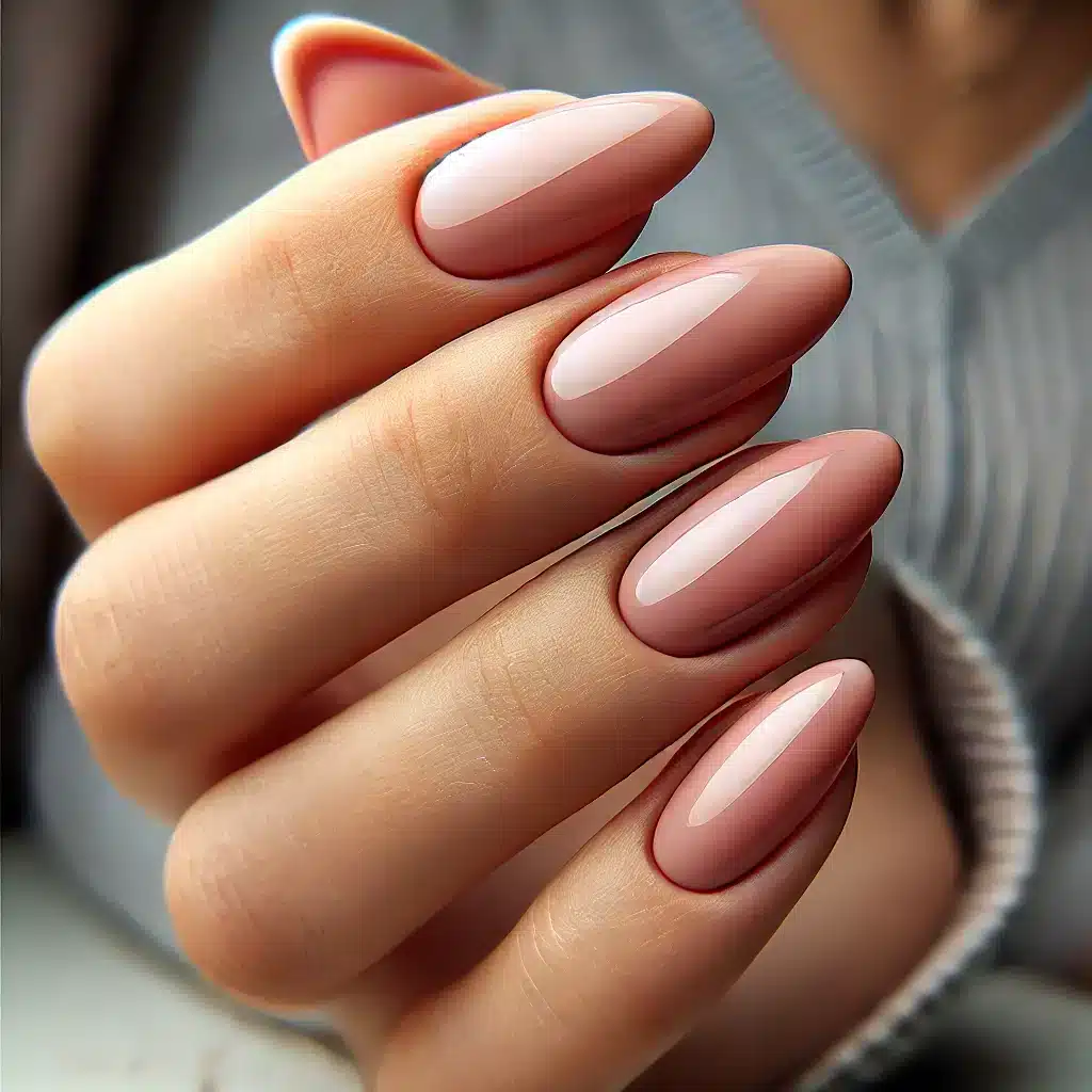 Gros plan sur une main avec une manucure russe, ongles longs en forme d'amande avec un fini brillant nude.